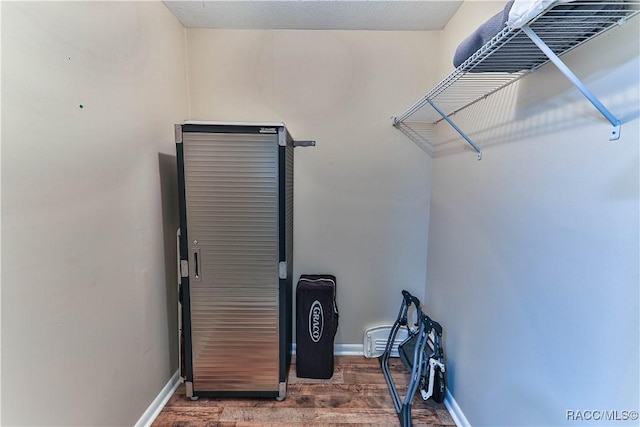 walk in closet with dark hardwood / wood-style flooring