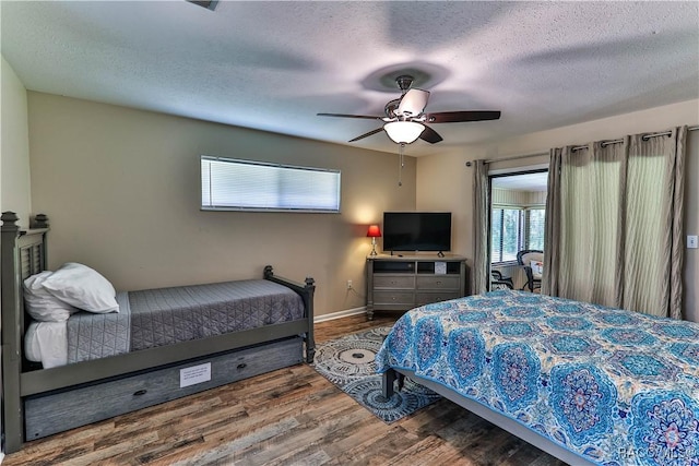 bedroom featuring hardwood / wood-style floors, ceiling fan, and a textured ceiling