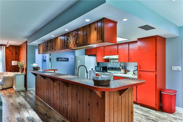 kitchen with sink, black appliances, dark hardwood / wood-style floors, and a notable chandelier