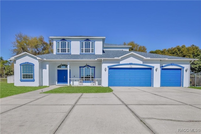 traditional home featuring stucco siding, driveway, a porch, a front yard, and an attached garage