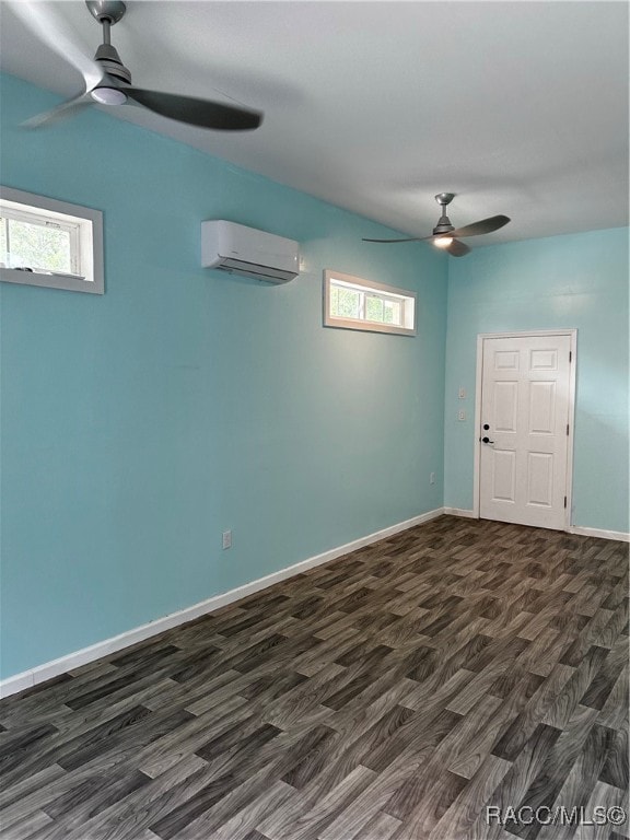 unfurnished room with a ceiling fan, dark wood-style flooring, a wall mounted air conditioner, and baseboards