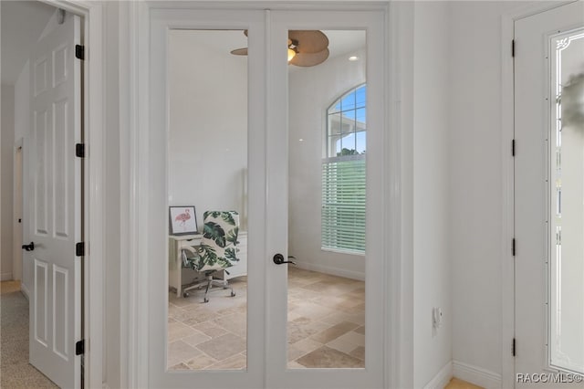 interior space with stone finish flooring, french doors, and baseboards