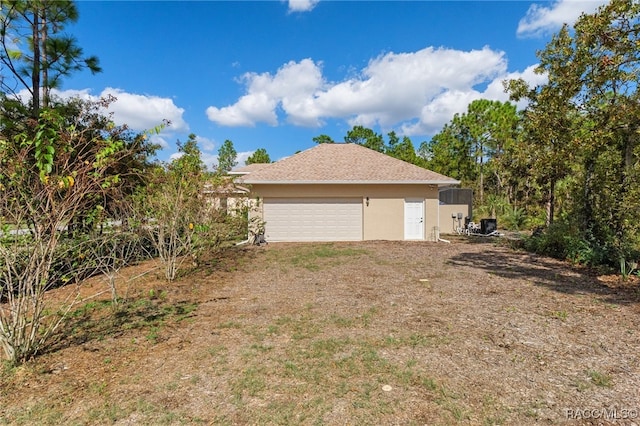 view of side of property with a garage and stucco siding