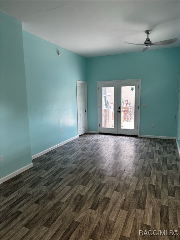 empty room featuring french doors, dark wood finished floors, baseboards, and ceiling fan