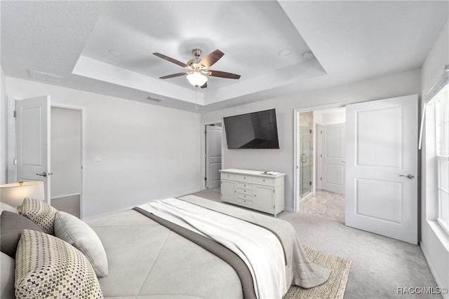 carpeted bedroom featuring ceiling fan and a raised ceiling