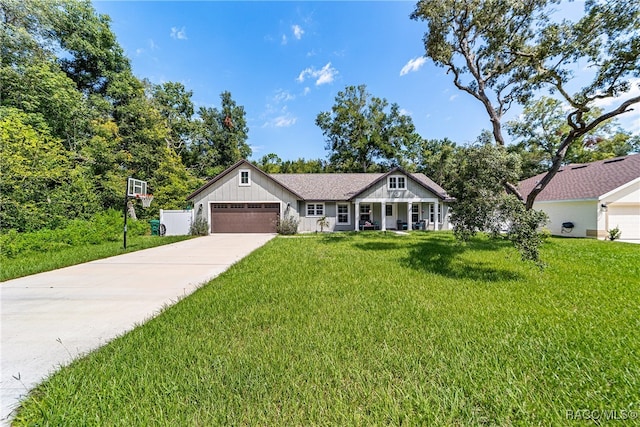 view of front of home featuring a porch, a front yard, and a garage