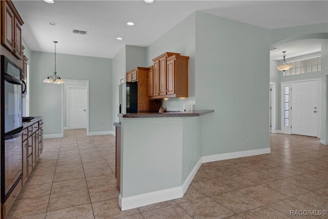 1918 W Crystal Mae Path, Lecanto, FL 34461 - kitchen featuring light tile patterned flooring, dark countertops, arched walkways, visible vents, and pendant lighting
