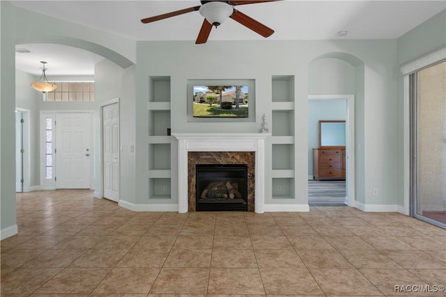 1918 W Crystal Mae Path, Lecanto, FL 34461 - unfurnished living room featuring ceiling fan, tile patterned floors, built in shelves, baseboards, and a high end fireplace