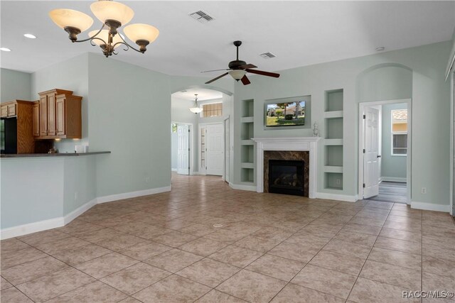 1918 W Crystal Mae Path, Lecanto, FL 34461 - unfurnished living room featuring visible vents, baseboards, built in shelves, ceiling fan with notable chandelier, and light tile patterned floors