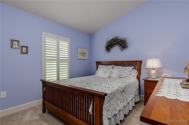 carpeted bedroom with vaulted ceiling