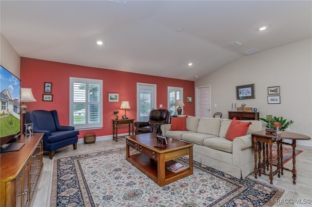 living room with light wood-type flooring and lofted ceiling