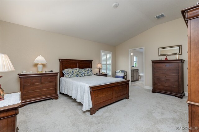 carpeted bedroom with lofted ceiling and connected bathroom