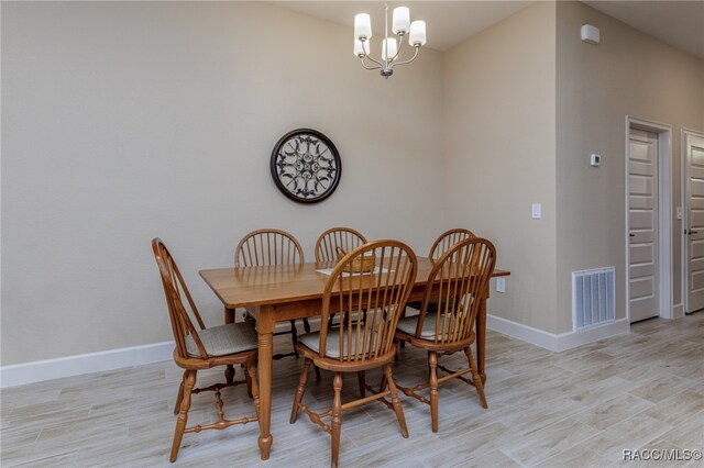 dining space featuring light hardwood / wood-style floors and an inviting chandelier