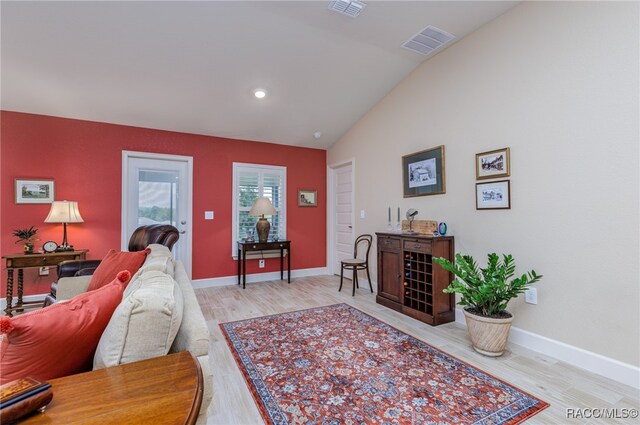 living room featuring lofted ceiling and light wood-type flooring