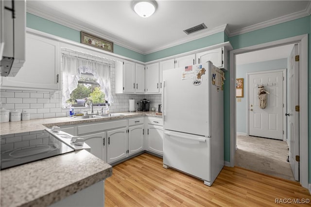 1179 N Point Lonesome Rd, Inverness, FL 34453 - kitchen with freestanding refrigerator, a sink, ornamental molding, light countertops, and tasteful backsplash