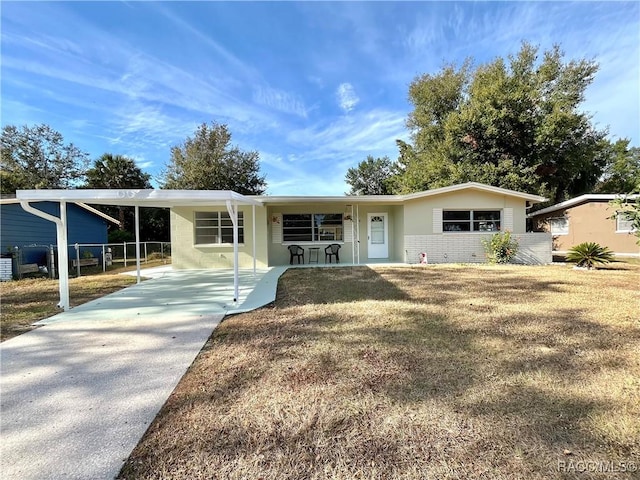 single story home featuring a front yard, a porch, and a carport