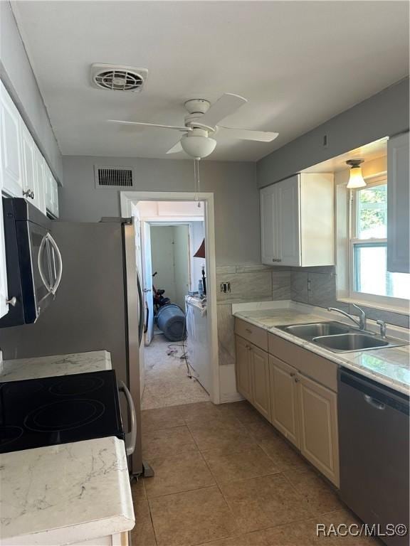 kitchen with sink, white cabinets, and black dishwasher