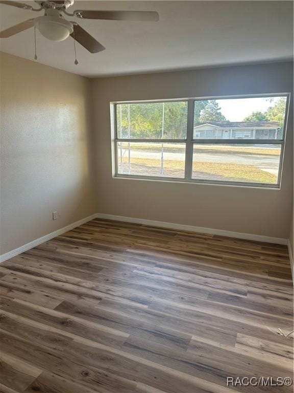 unfurnished room with ceiling fan and dark hardwood / wood-style floors