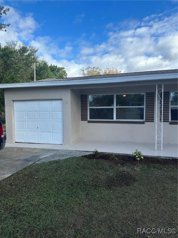 ranch-style home with a garage and a front lawn