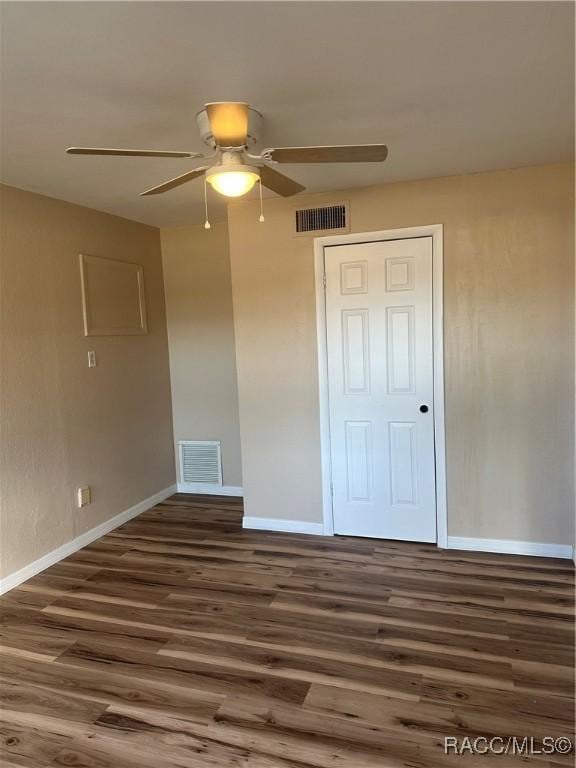 unfurnished bedroom featuring a closet, ceiling fan, and dark hardwood / wood-style flooring