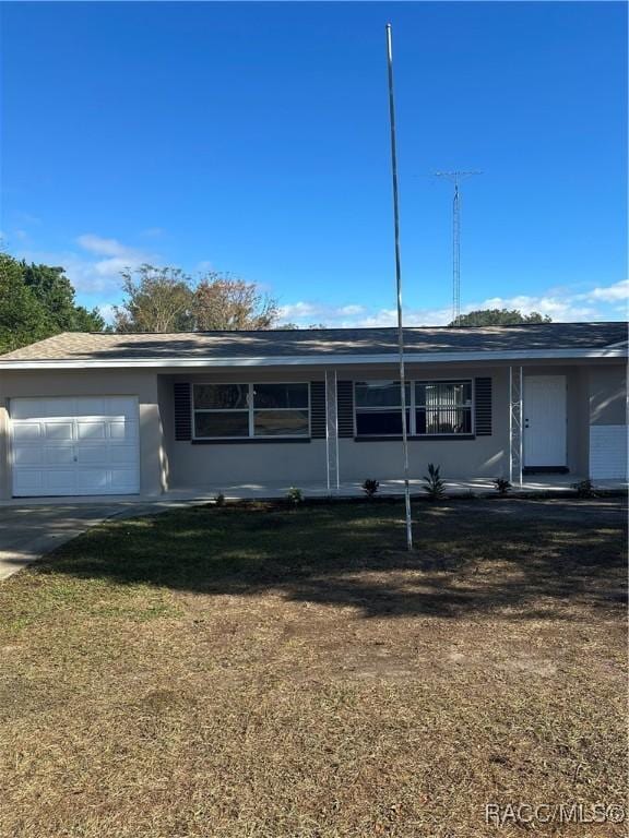 single story home featuring a garage and a front lawn