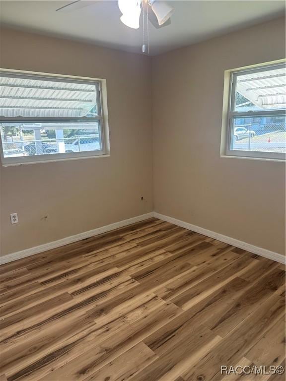 unfurnished room with ceiling fan and wood-type flooring