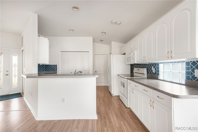 kitchen with white appliances, white cabinetry, and backsplash