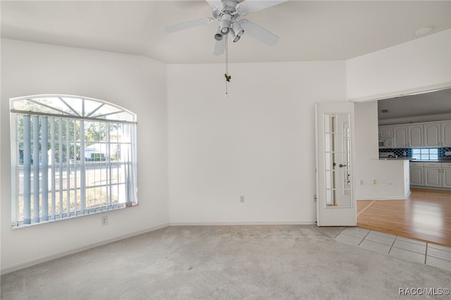 empty room with ceiling fan and light tile patterned floors