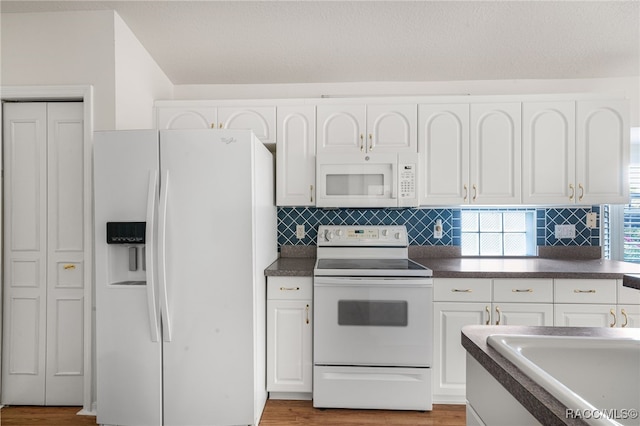 1868 W Shanelle Path, Lecanto, FL 34461 - kitchen featuring white appliances, dark countertops, and white cabinets