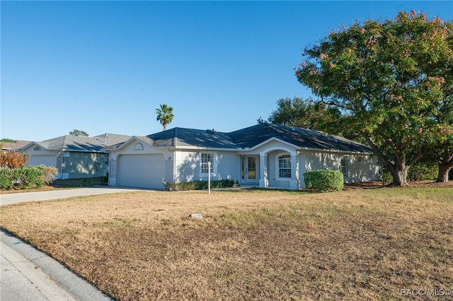 ranch-style house with a garage and a front lawn