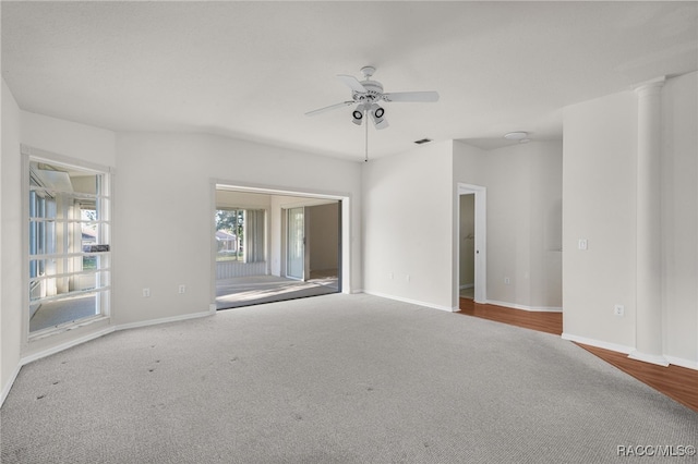 carpeted empty room featuring decorative columns and ceiling fan