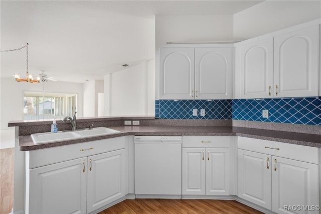 kitchen with dishwasher, white cabinets, sink, tasteful backsplash, and kitchen peninsula