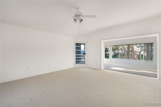 carpeted spare room with ceiling fan and lofted ceiling