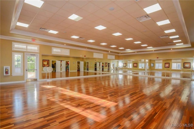 workout room with hardwood / wood-style flooring and a tray ceiling