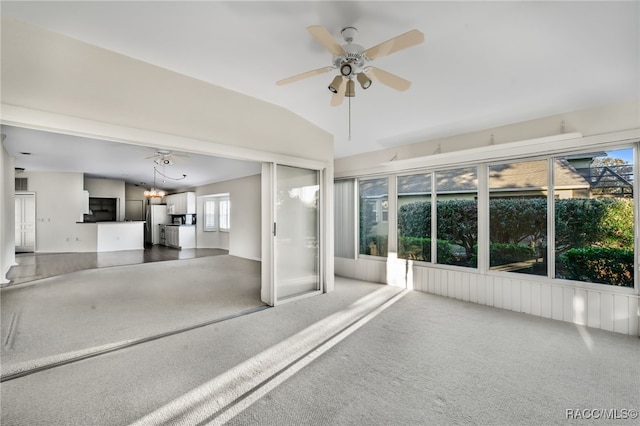 unfurnished sunroom with ceiling fan with notable chandelier and vaulted ceiling