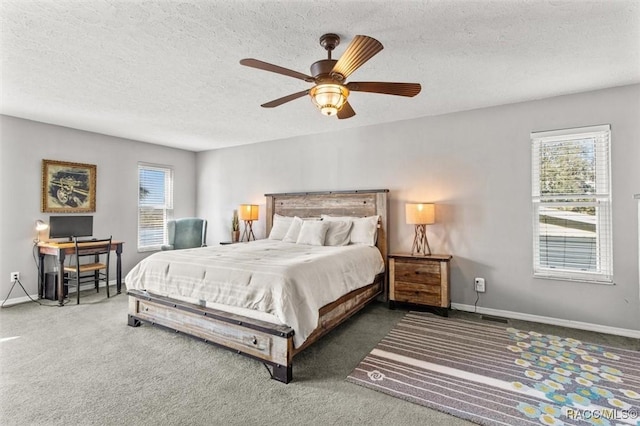 carpeted bedroom featuring ceiling fan and a textured ceiling