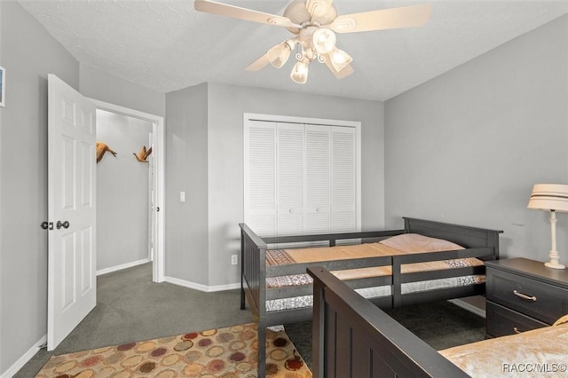 bedroom featuring ceiling fan, a textured ceiling, a closet, and dark colored carpet