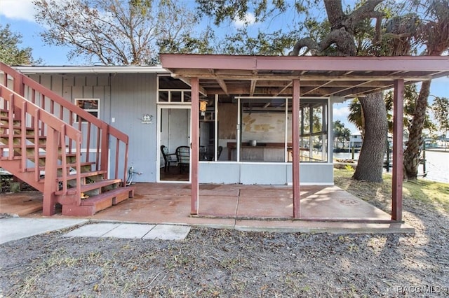 back of property with a sunroom and a patio