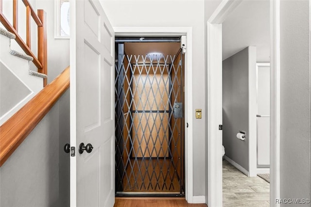 interior space with light hardwood / wood-style floors and elevator