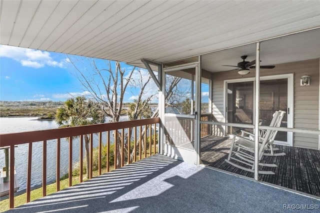 exterior space with ceiling fan and a water view