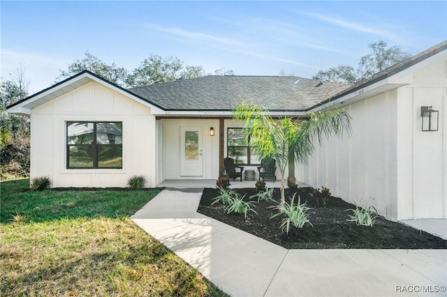 property entrance with a yard and covered porch