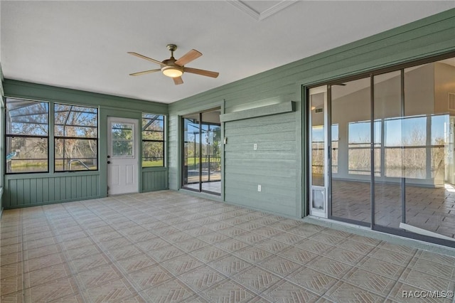 unfurnished sunroom with ceiling fan