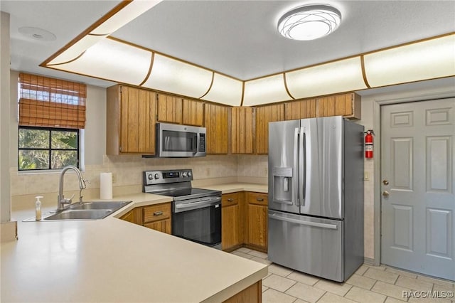 kitchen featuring sink, decorative backsplash, light tile patterned flooring, kitchen peninsula, and stainless steel appliances