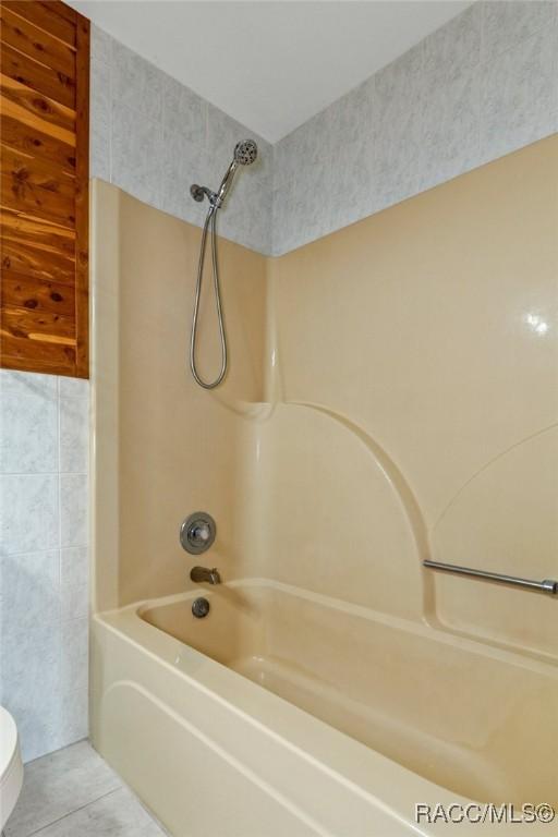 bathroom featuring tile patterned floors, shower / bathing tub combination, and toilet