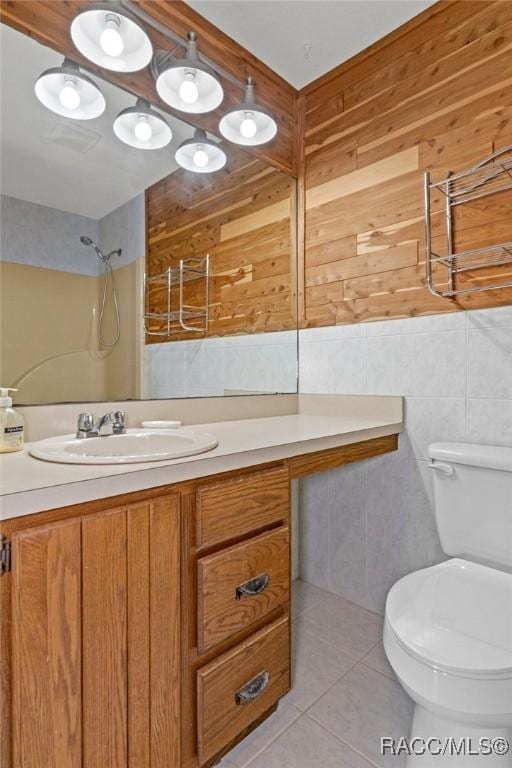 bathroom with walk in shower, tile patterned flooring, toilet, wooden walls, and vanity