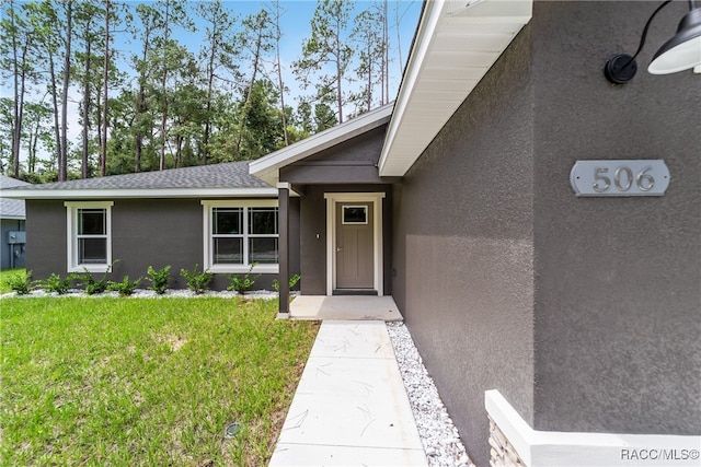 entrance to property featuring a yard