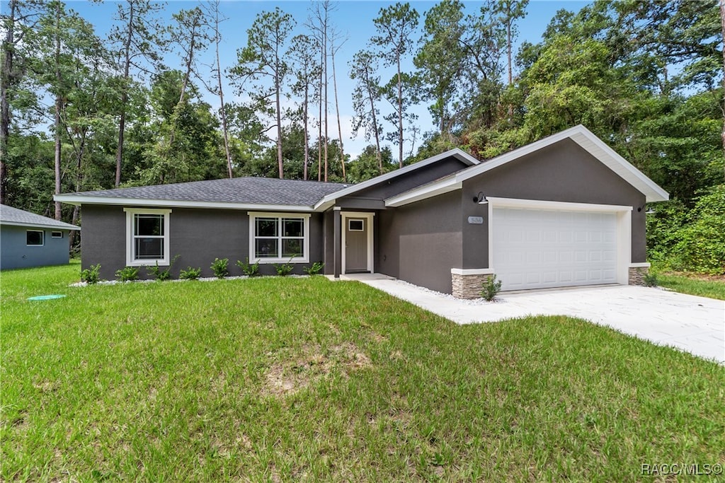 single story home featuring a garage and a front lawn