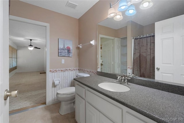 full bath with toilet, a wainscoted wall, vanity, visible vents, and tile patterned floors