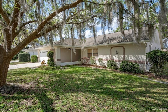 ranch-style house featuring a front yard, driveway, an attached garage, and stucco siding