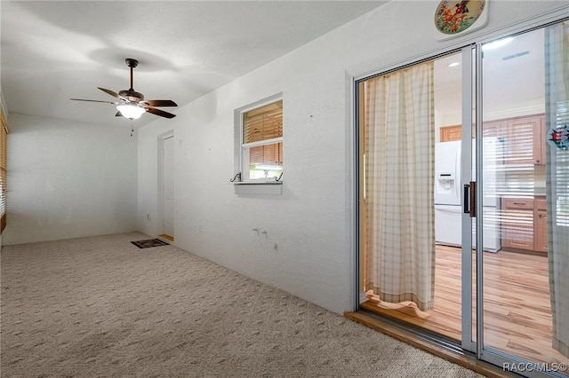 unfurnished room with light carpet and ceiling fan